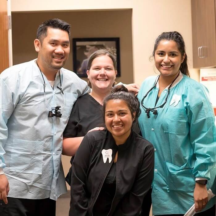 Smiling dental team members at reception desk