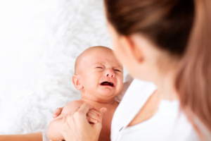 a parent comforting her crying infant 