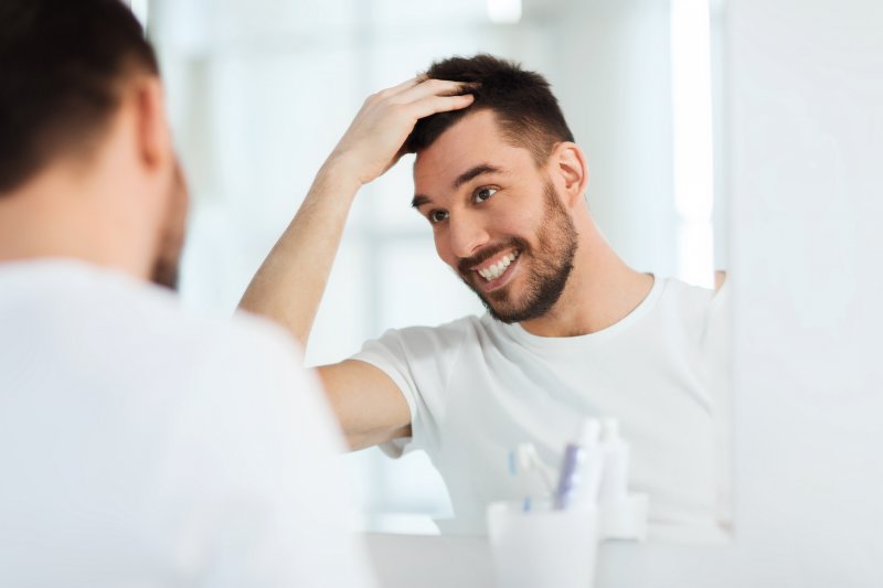Dental implants patient smiling in mirror