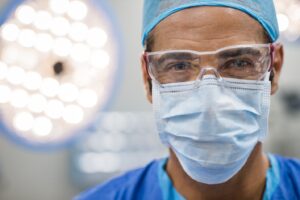 Close-up of dentist wearing mask and cap.